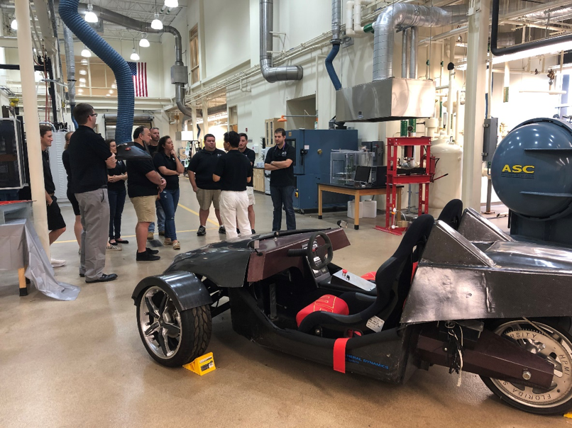 3 MSSE students and faculty tour HPMI, carbon fiber electric vehicle.png